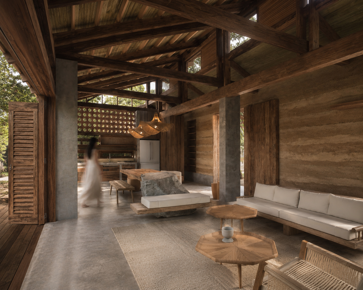Zona social de UMA Beach Villas: sala y cocina bajo la estructura de madera, con muro de tapia pisada, columnas de concreto y piso afinado — GUA 01 en Palomino, La Guajira, LINEA PRIMA, arquitectos en Bogotá.