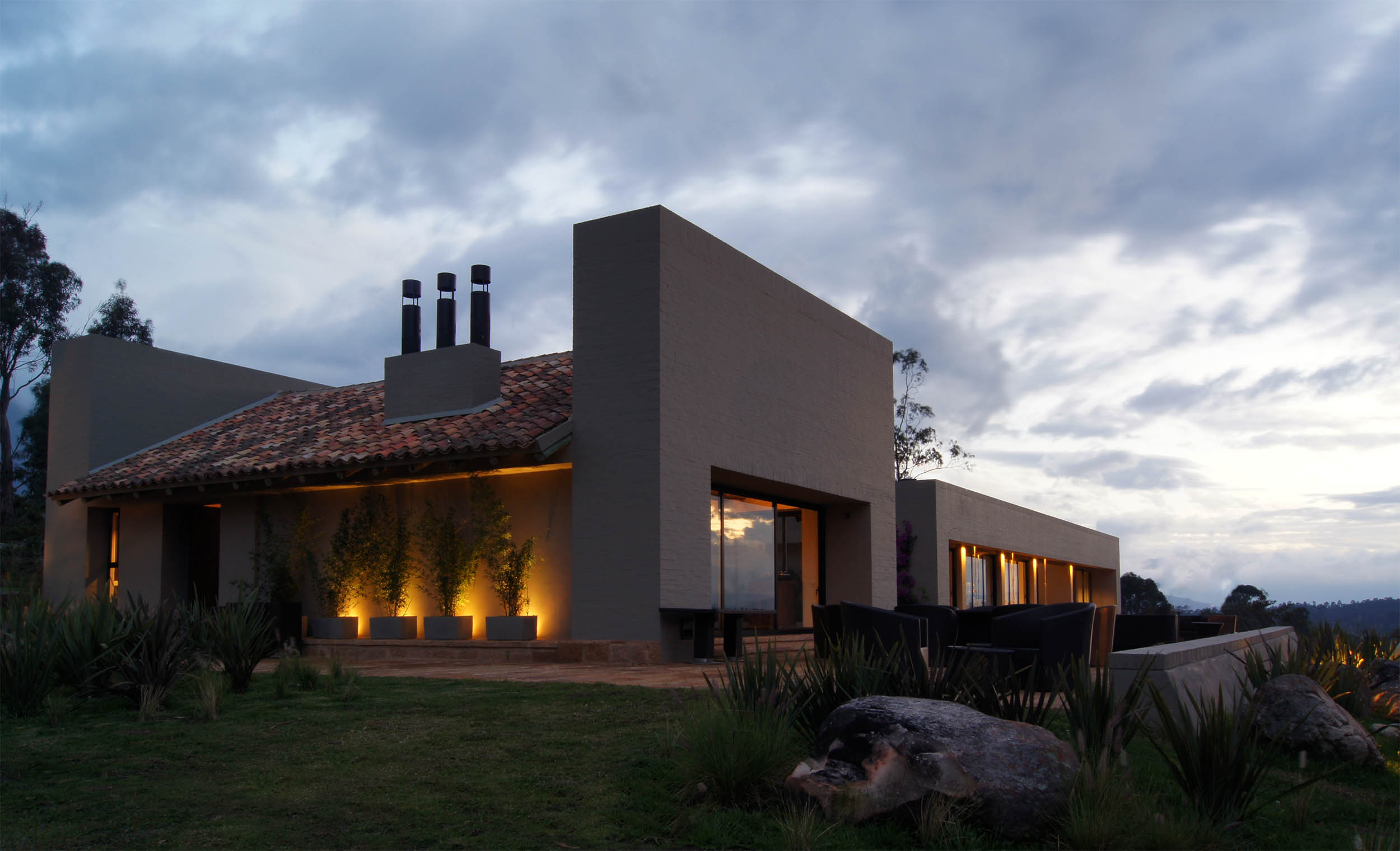 Casa de teja de barro y ladrillo con hamaca al atardecer